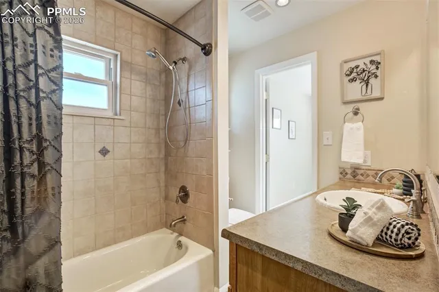 a bathroom with a granite countertop sink a bathtub and shower