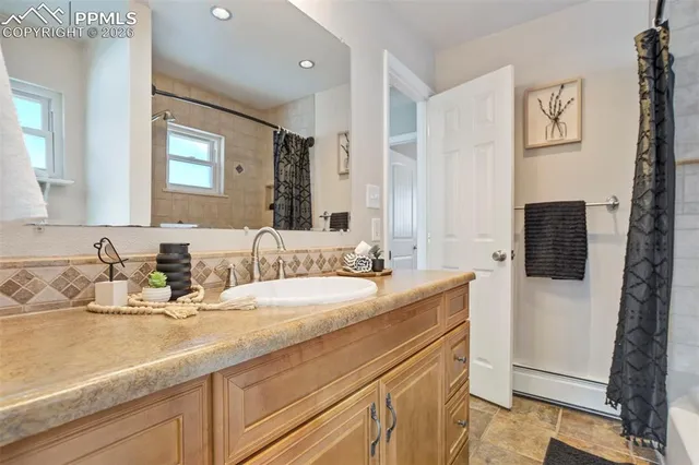 a bathroom with a granite countertop sink and a mirror