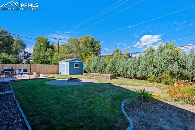 a view of a backyard with potted plants and wooden fence