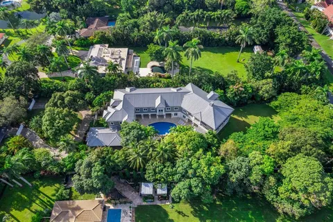 an aerial view of a house with a garden and lake view