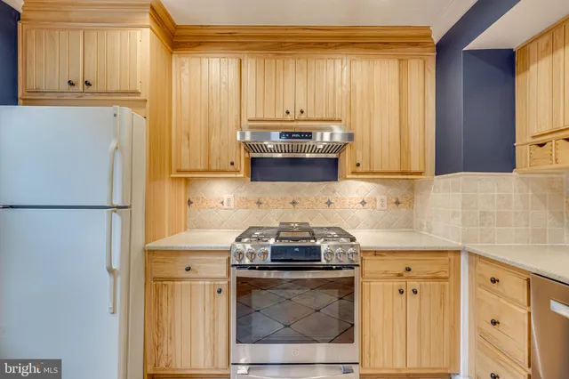a kitchen with granite countertop a refrigerator stove and microwave with cabinets