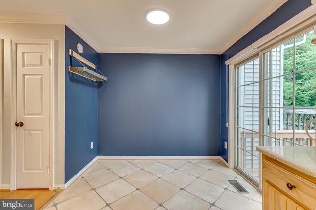 a view of a hallway to a bedroom with wooden floor and windows