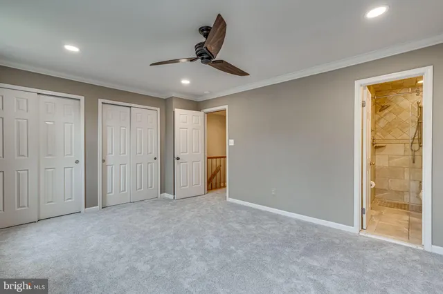 a view of an empty room and chandelier fan