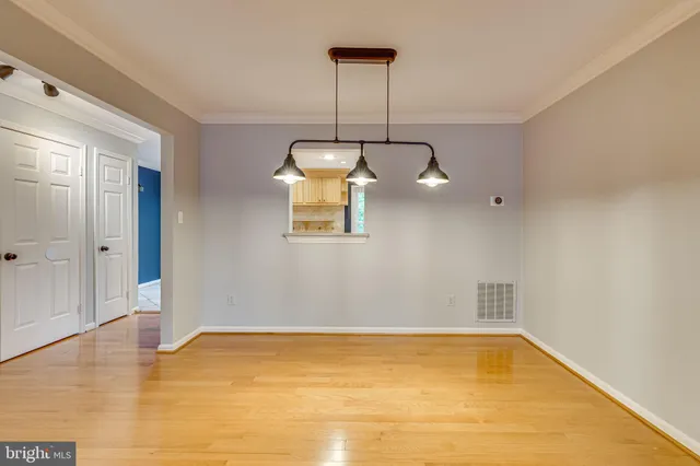 a view of a room with wooden floor and chandelier