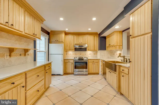 a kitchen with white cabinets and appliances