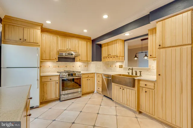 a kitchen with stainless steel appliances granite countertop a refrigerator and a stove top oven