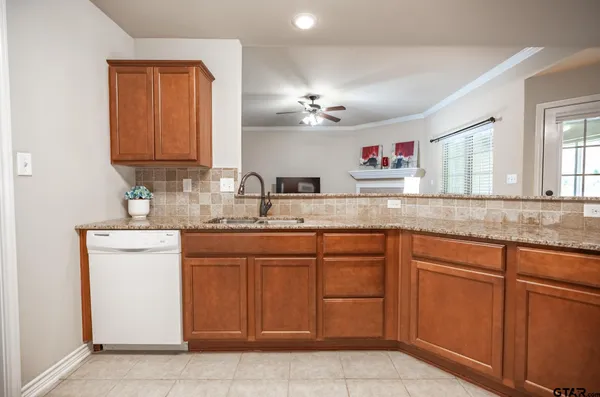 a large kitchen with stainless steel appliances granite countertop a sink and cabinets