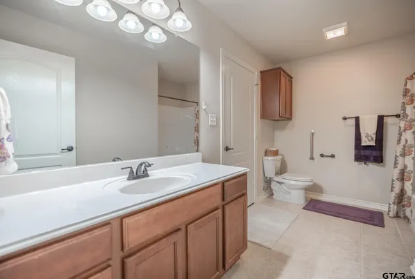 a spacious bathroom with a granite countertop sink and mirror