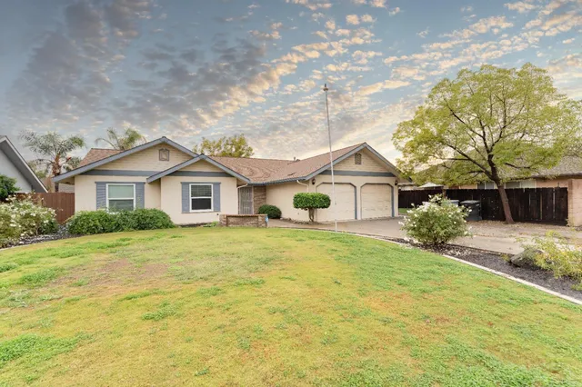 a view of a yard in front of a house with a large tree