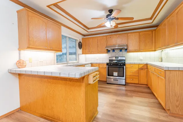 a kitchen with granite countertop a stove a sink and a refrigerator