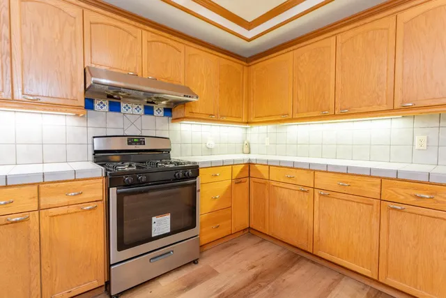 a kitchen with stainless steel appliances granite countertop a stove and a microwave