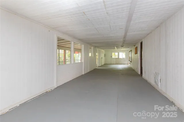 a view of a big room with wooden floor and windows