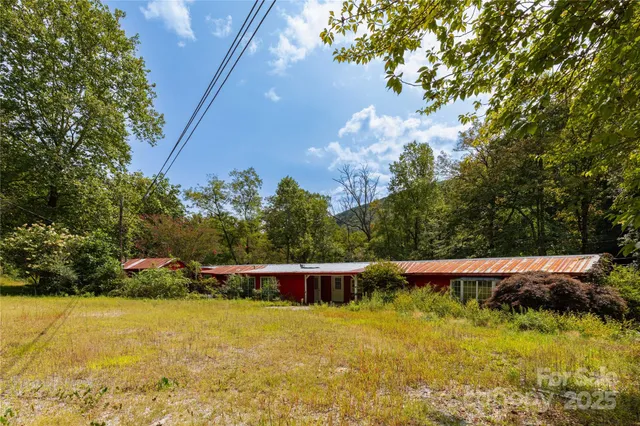 a view of yard with swimming pool and trees in the background