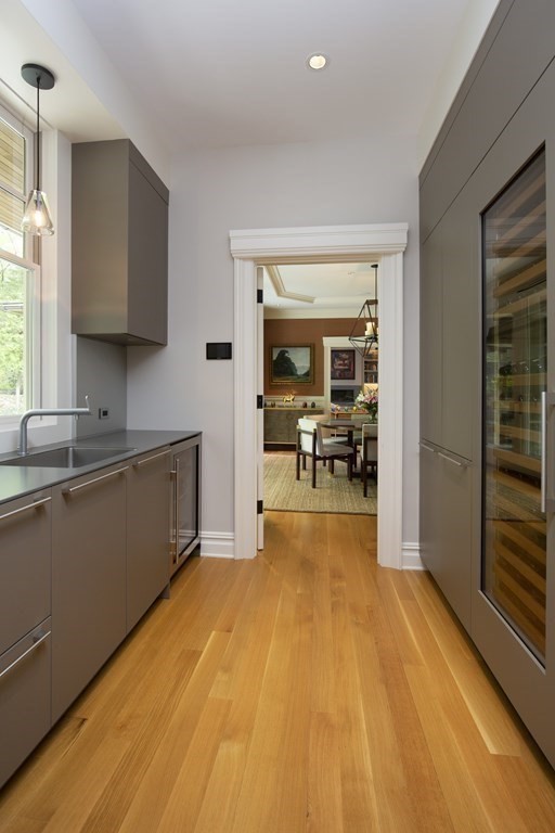 55 Ridge Hill Farm Road Wellesley, MA 02482 - Photo 13 of 32 a view of a kitchen with kitchen island a sink wooden floor and a large window in the back