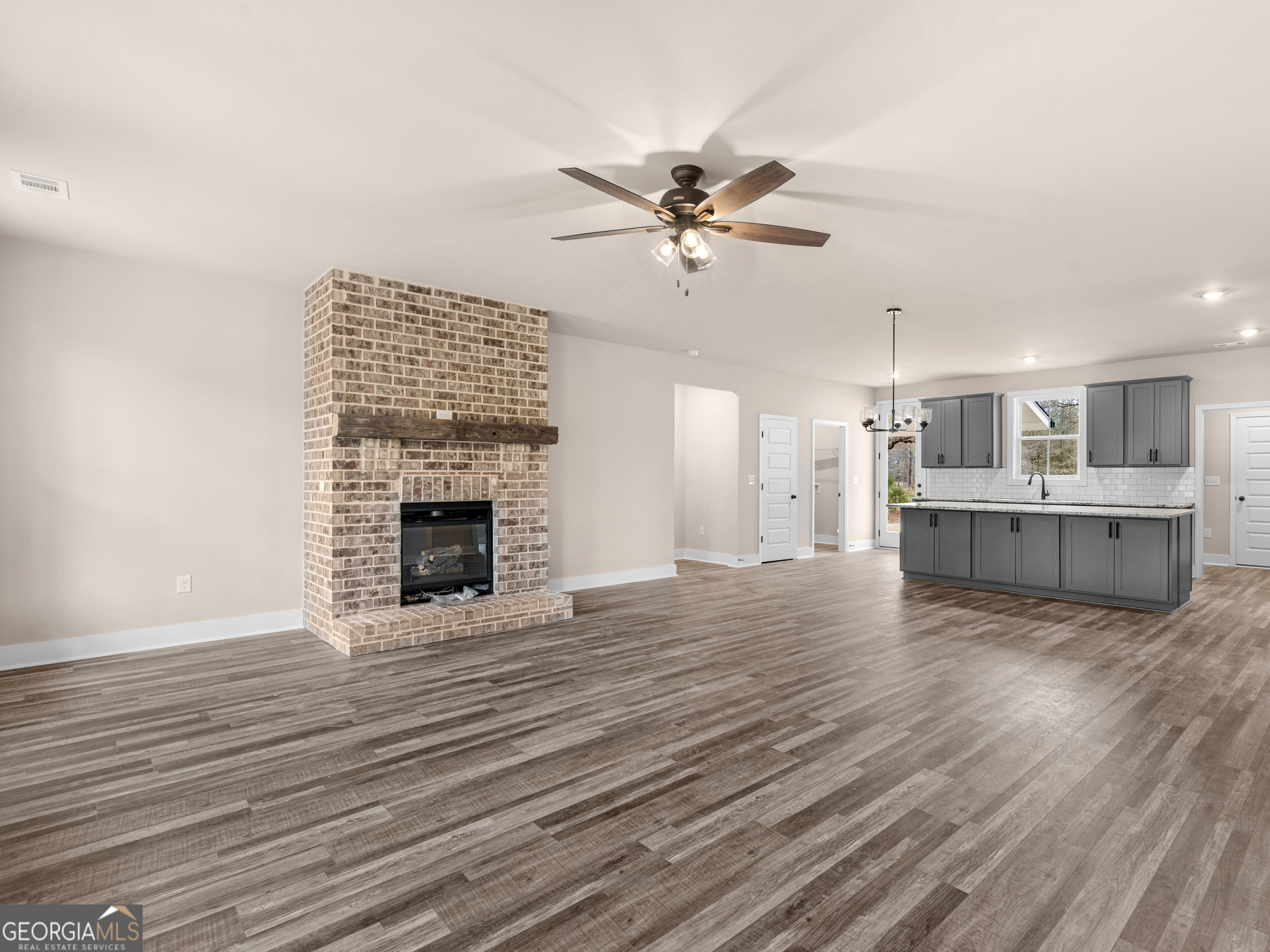 160 Loyd Road Mansfield, GA 30056 - Photo 15 of 53 a view of a livingroom with a fireplace a ceiling fan and wooden floor