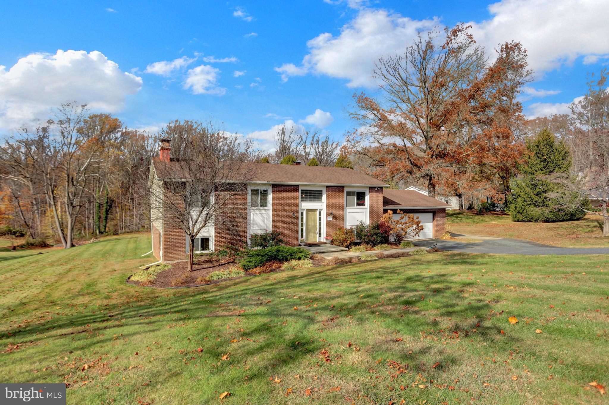 a view of a house with backyard and trees