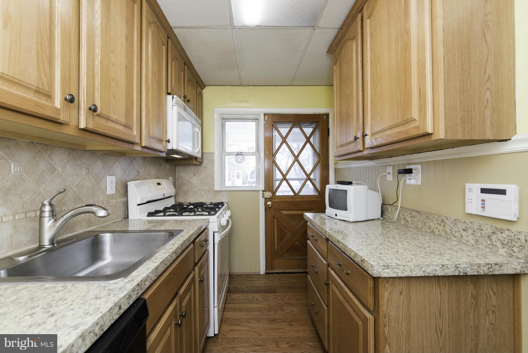 1900 Barry Road Baltimore, MD 21222 - Photo 14 of 30 a kitchen with granite countertop a sink a stove and cabinets