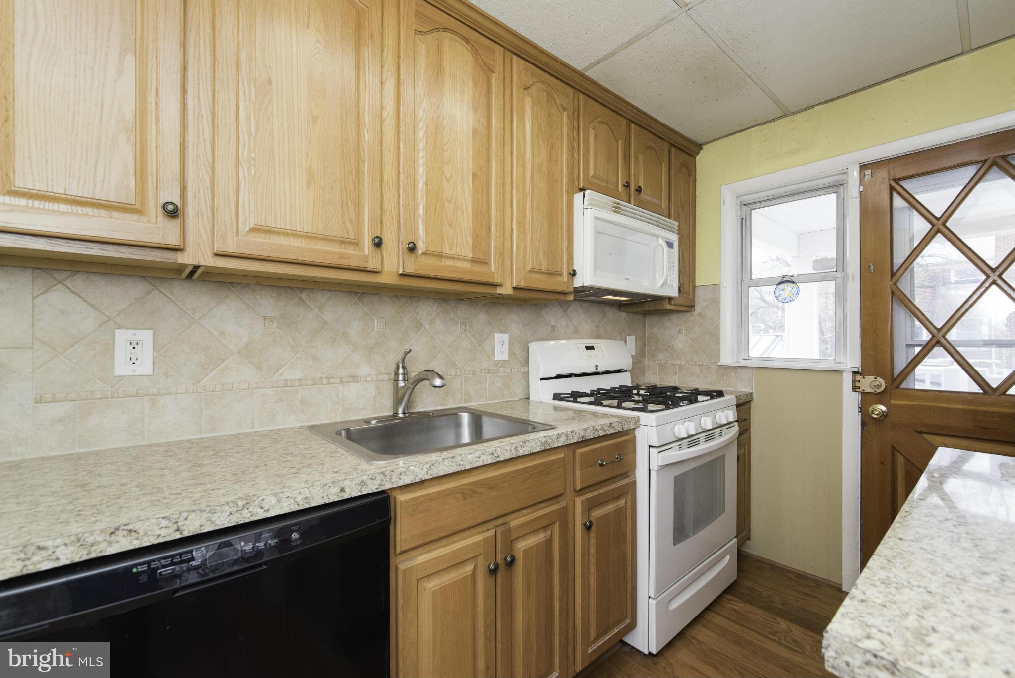1900 Barry Road Baltimore, MD 21222 - Photo 15 of 30 a kitchen with stainless steel appliances granite countertop a stove a sink dishwasher and cabinets with wooden floor