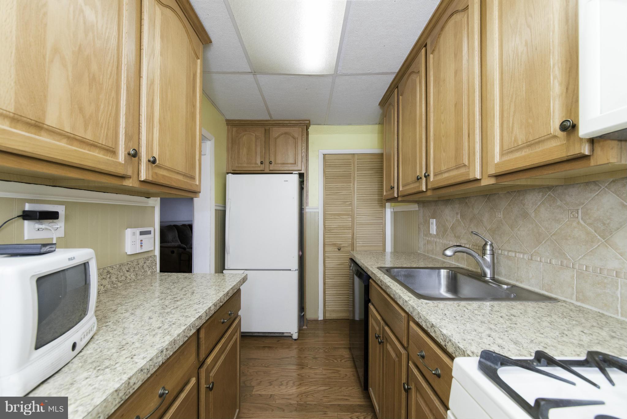 1900 Barry Road Baltimore, MD 21222 - Photo 18 of 30 a kitchen with stainless steel appliances granite countertop a sink a stove and a refrigerator