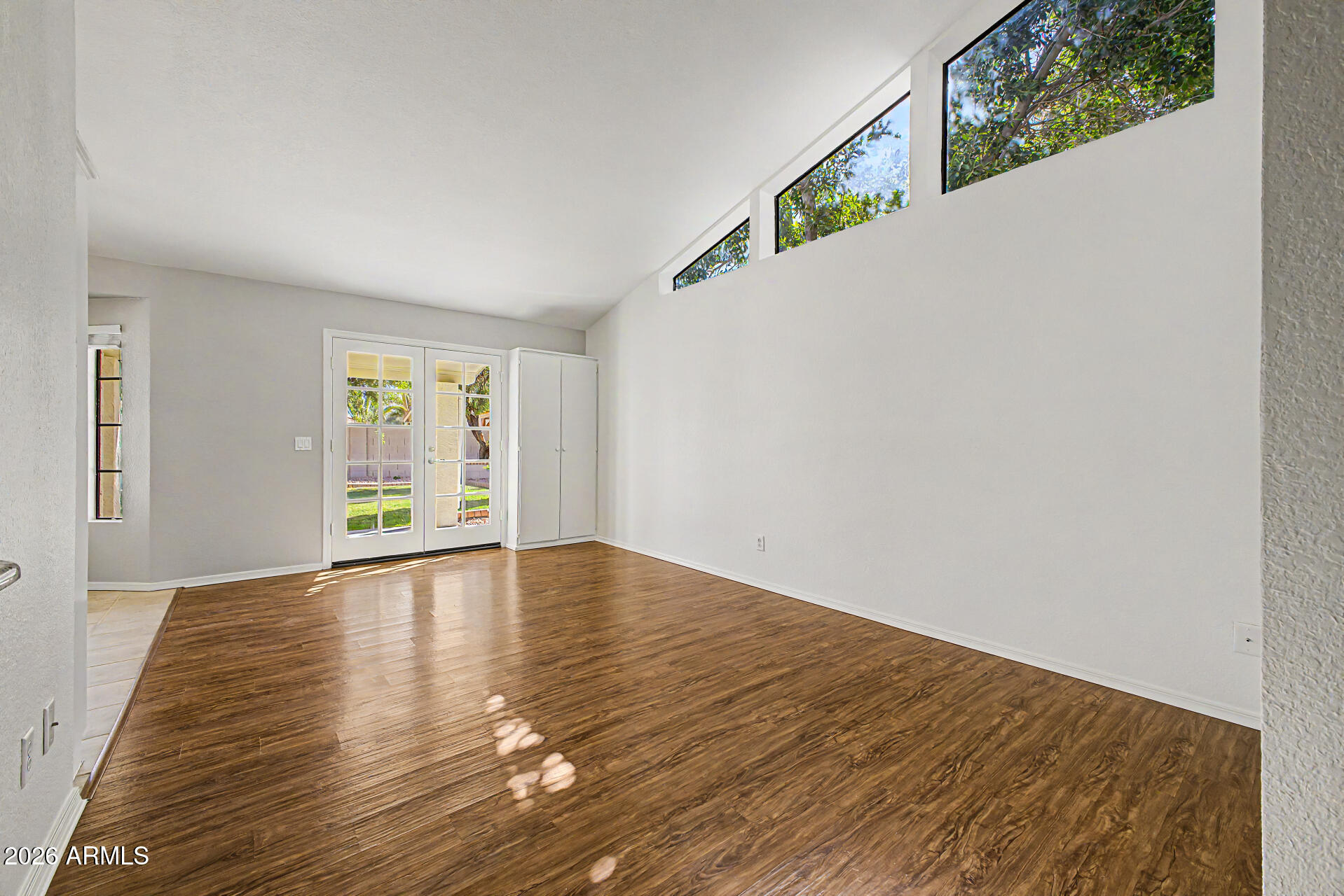 6725 West Utopia Road Glendale, AZ 85308 - Photo 4 of 27 a view of an empty room with wooden floor and a window