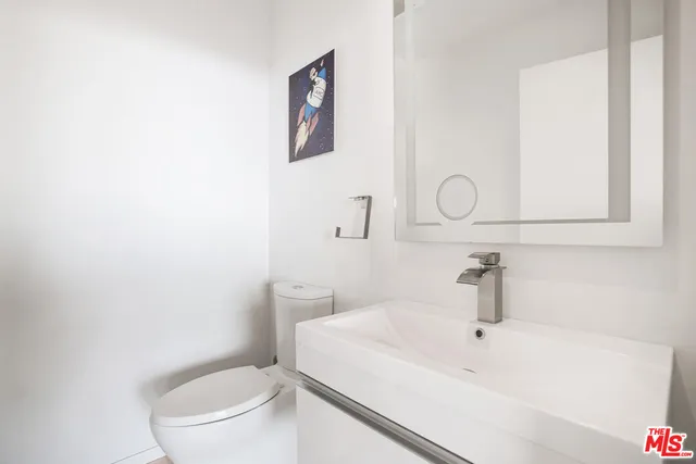 a white toilet sitting next to a bathroom sink