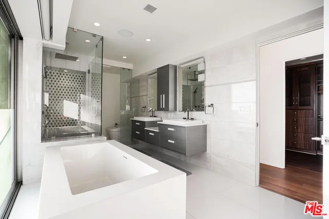 a large bathroom with a tub sink and mirror