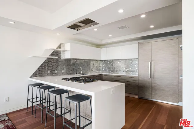 a kitchen that has a sink a stove and a refrigerator