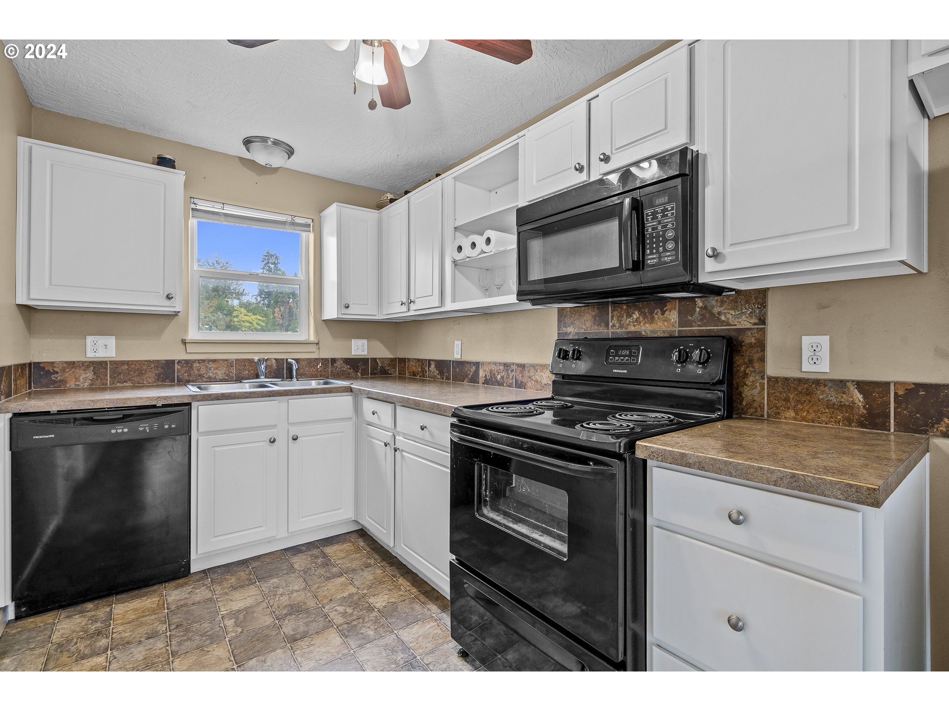 1275 30th Street Springfield, OR 97478 - Photo 10 of 28 a kitchen with stainless steel appliances granite countertop a stove a sink and a microwave