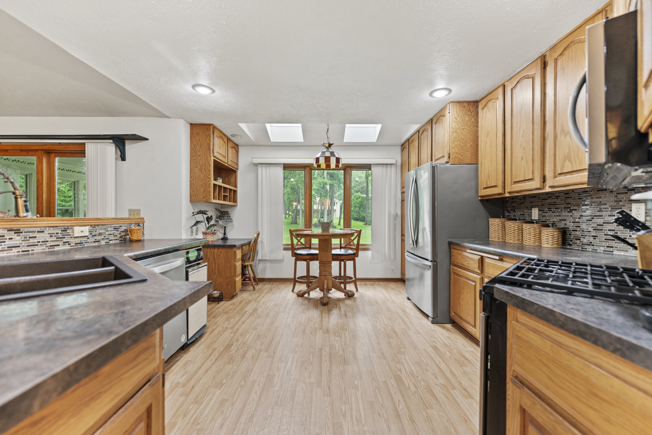 1506 Pier Drive Davis, IL 61019 - Photo 8 of 47 a kitchen with stainless steel appliances a refrigerator a stove a sink dishwasher and wooden cabinets with wooden floor