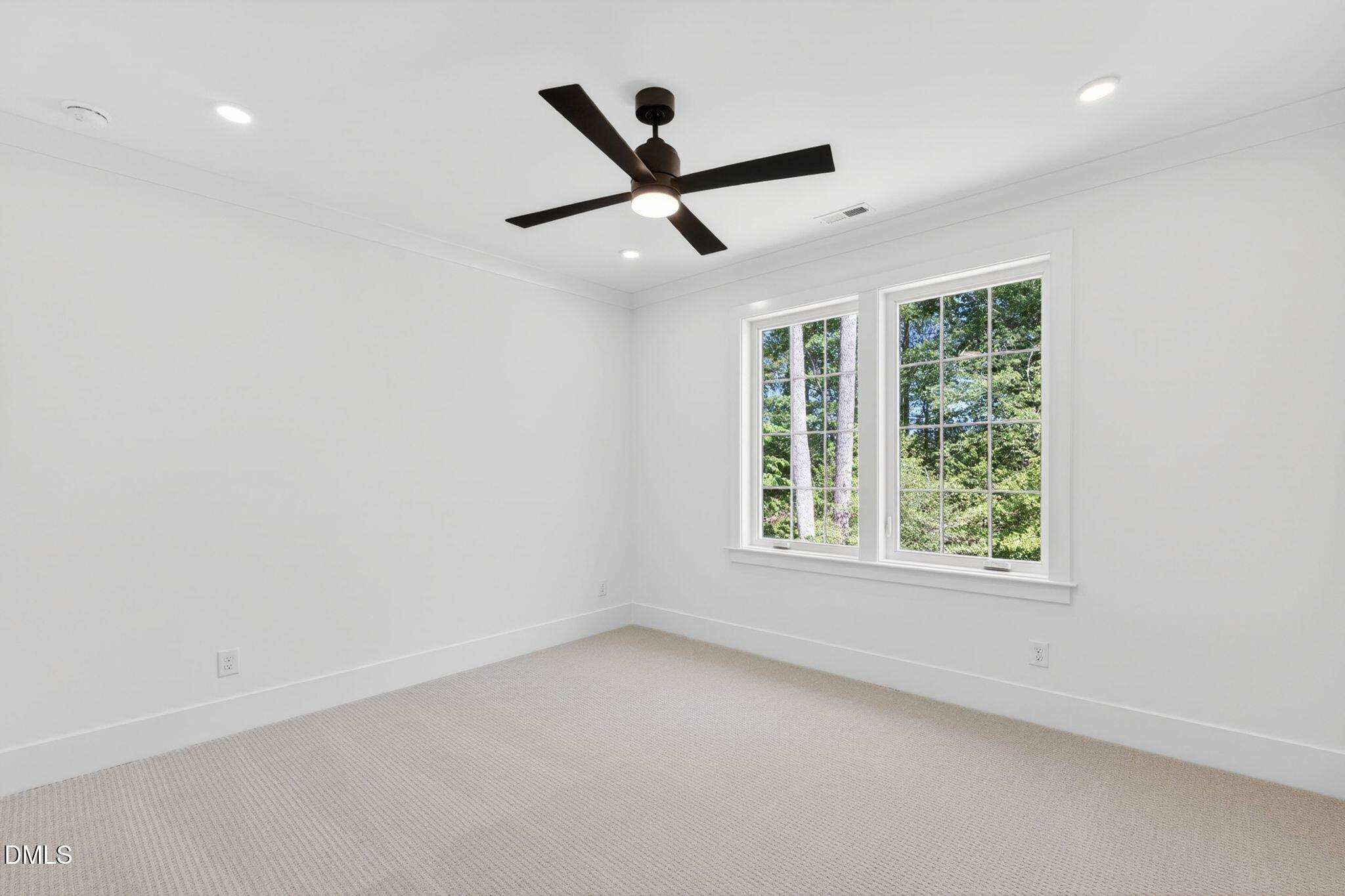 3340 Colby Chase Drive Apex, NC 27539 - Photo 50 of 80 an empty room with a window and a ceiling fan