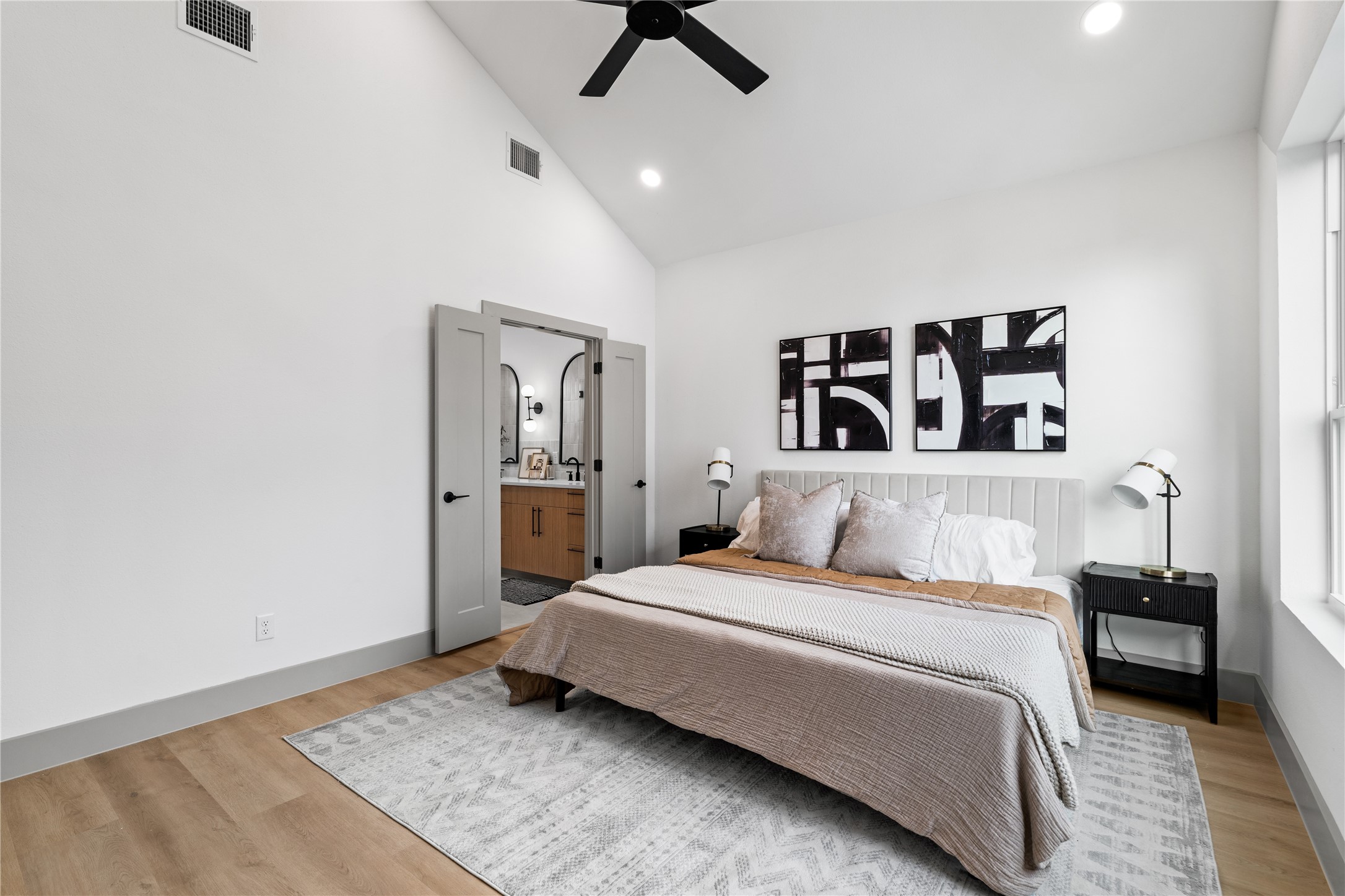 2950 Pitzlin Street Houston, TX 77023 - Photo 23 of 37 Framed by vaulted ceilings and wide-plank flooring, the primary suite flows seamlessly into a spa-inspired bath through double doors—offering both comfort and convenience in a refined, retreat-like setting. A perfect blend of privacy and polish.