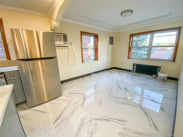 a view of a kitchen with fridge and wooden floor