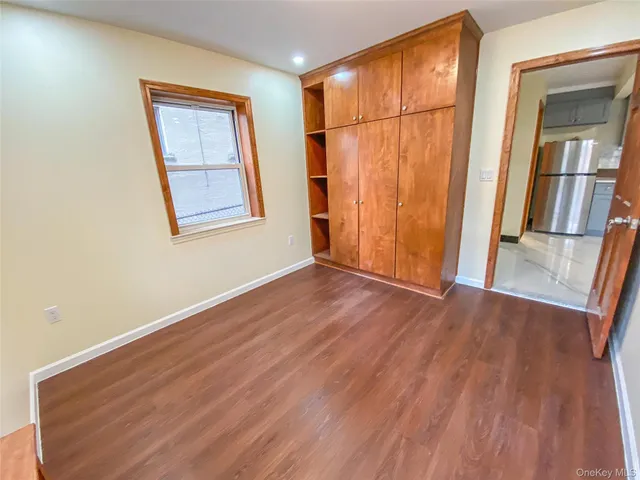 an empty room with wooden floor and a window