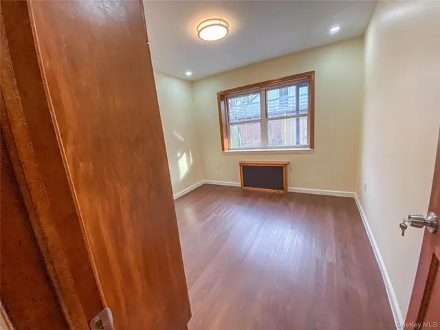 a view of a room with wooden floors and window