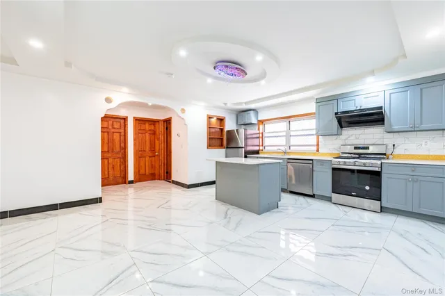 a kitchen with stainless steel appliances granite countertop a stove sink and cabinets