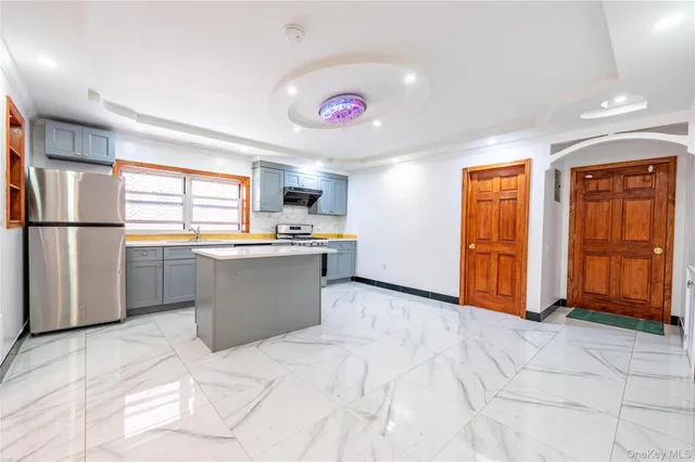 a kitchen with stainless steel appliances kitchen island granite countertop a refrigerator and a sink