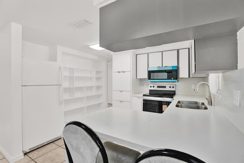 6701 Parkside Drive New Port Richey, FL 34653 - Photo 6 of 26 a kitchen with stainless steel appliances a stove refrigerator sink and cabinets