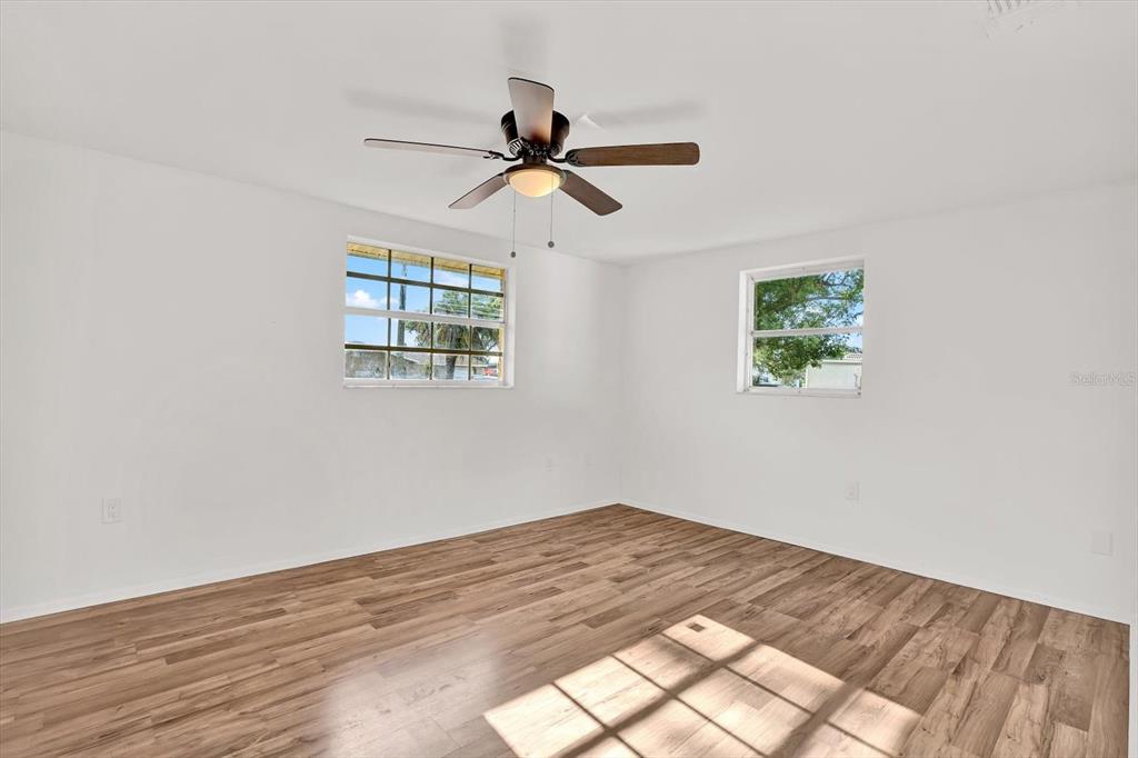 6701 Parkside Drive New Port Richey, FL 34653 - Photo 9 of 26 a view of empty room with wooden floor and fan