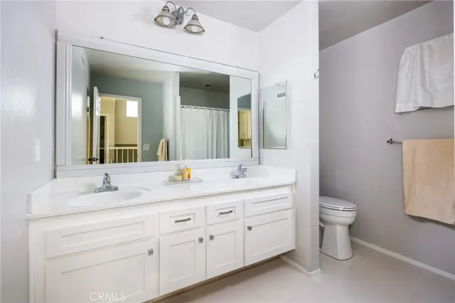a bathroom with a double vanity sink and a toilet