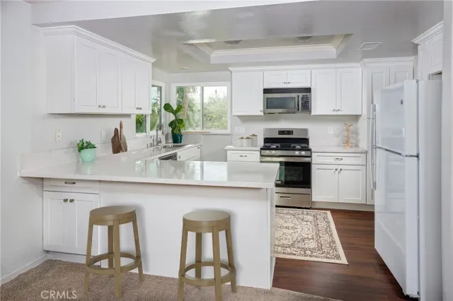 a kitchen with stainless steel appliances granite countertop a stove a sink and a refrigerator