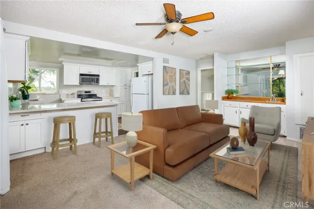 a living room with furniture and a kitchen view