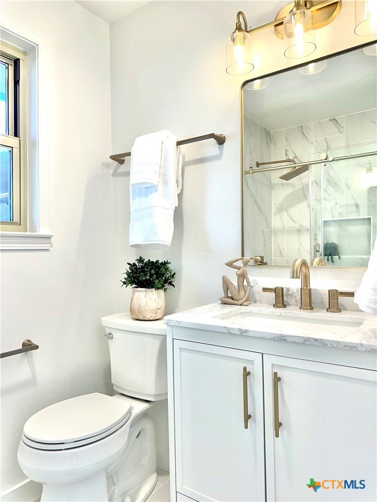 4412 Briar Cliff Road Temple, TX 76502 - Photo 19 of 28 a bathroom with a granite countertop toilet sink and mirror
