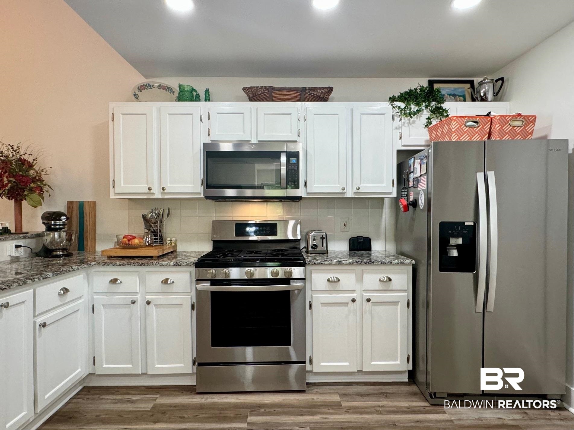 3200 Loop Road, Unit 55 Orange Beach, AL 36561 - Photo 8 of 40 Kitchen featuring light stone countertops, light hardwood / wood-style floors, appliances with stainless steel finishes, and white cabinetry