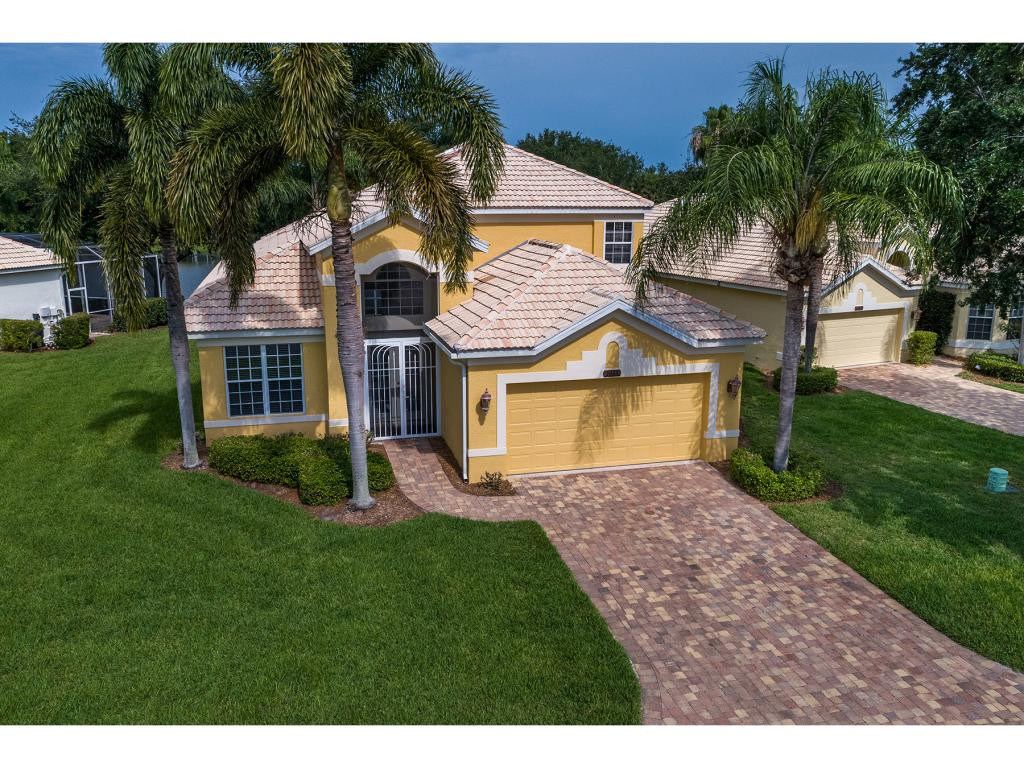 2011 Timarron Way Naples, FL 34109 - Photo 1 of 18 a front view of a house with a yard and garage