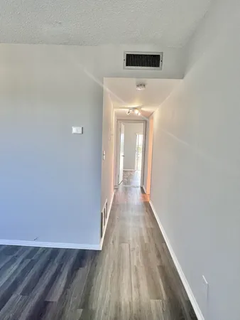 a view of a hallway with wooden floor