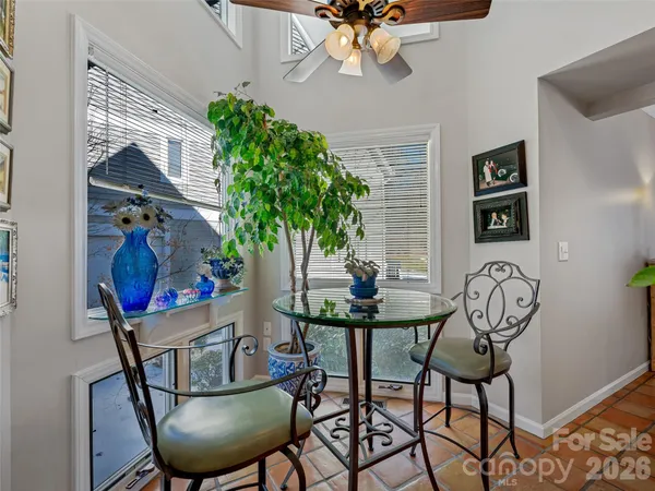 a kitchen with stainless steel appliances granite countertop a refrigerator a stove a sink dishwasher and a dining table with wooden floor