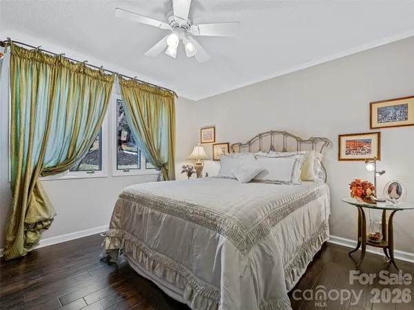 a bedroom with a bed a chandelier and a dresser