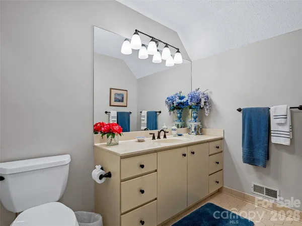 a bedroom with a bed and a large mirror with the bathroom