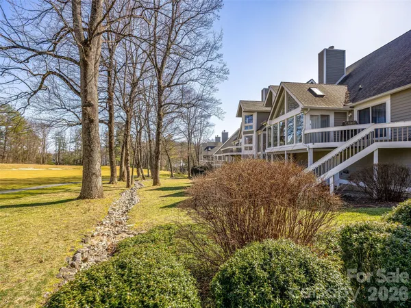 a view of swimming pool with outdoor seating and large trees