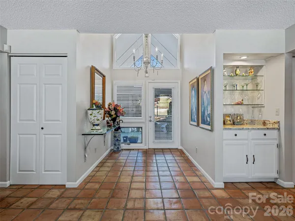 a hallway view with wooden floor and a chandelier